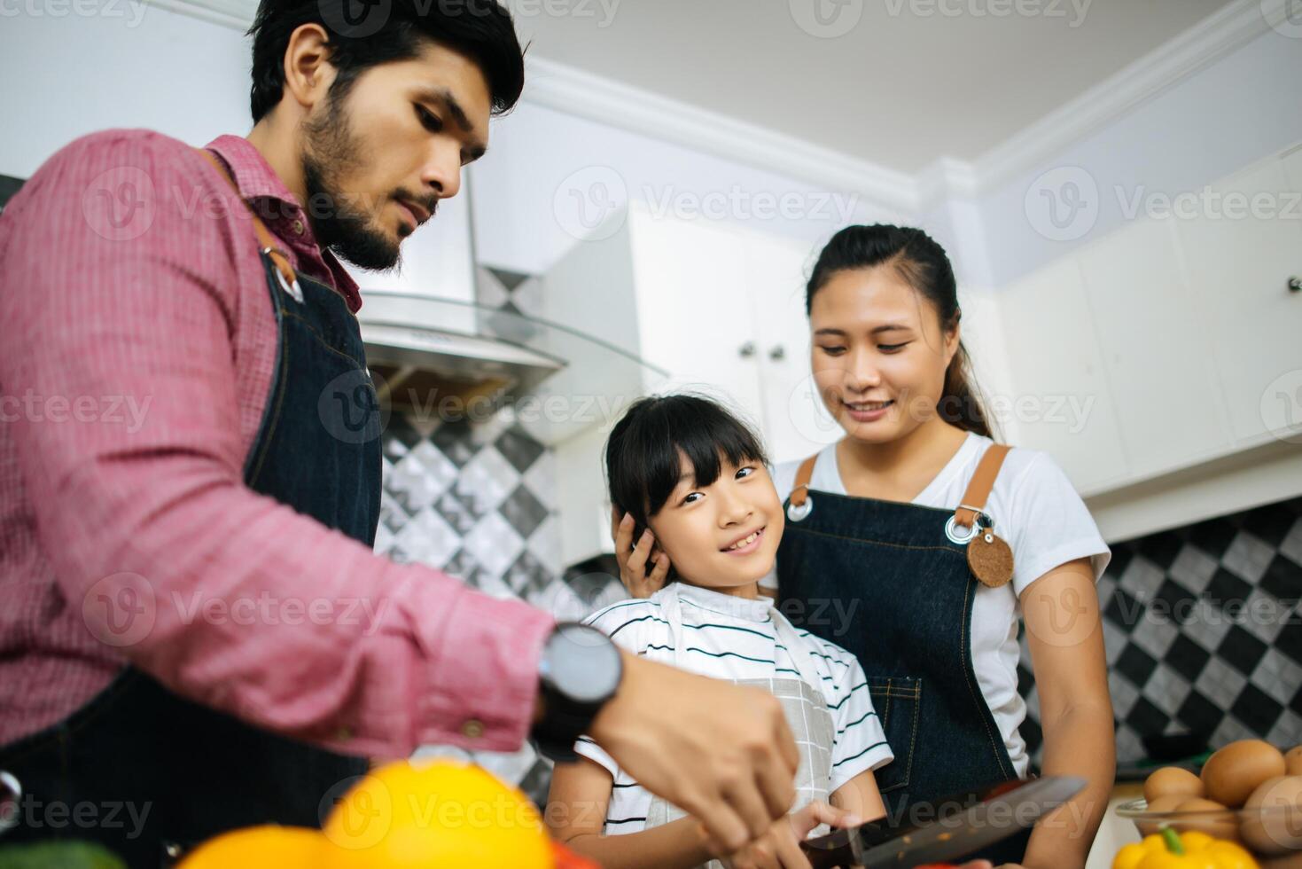 la famiglia felice aiuta a cucinare il pasto insieme nella cucina di casa. foto