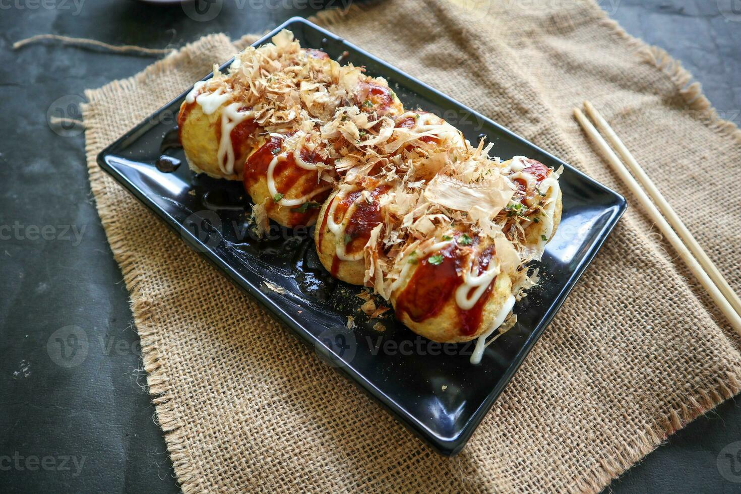 takoyaki è un' giapponese cibo, fatto a partire dal Grano Farina Impasto, polpo carne, o altro ripieni, servito con salsa, Maionese e guarnizione nel il modulo di katsuobushi o legna pesce trucioli. foto