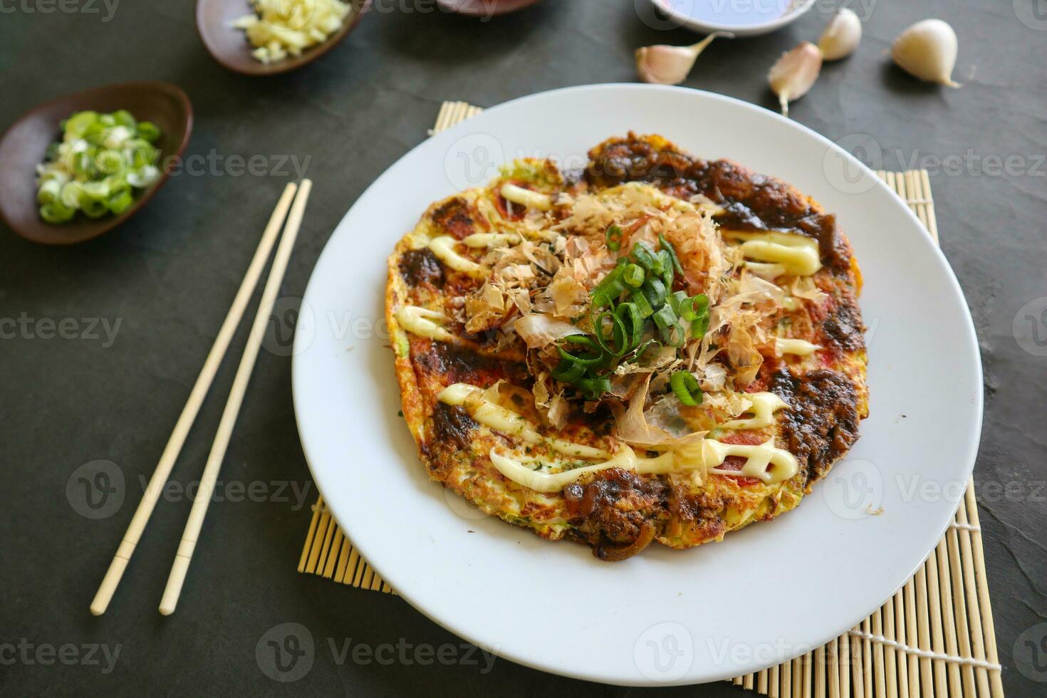 okonomyaki, tradizionale giapponese Pizza, giapponese caldo piatto Pizza a partire dal okonomiyaki. fatto di Farina quale è diluito con acqua o dashi, più cavolo, pollo uova, frutti di mare e fritte nel un' teppan foto