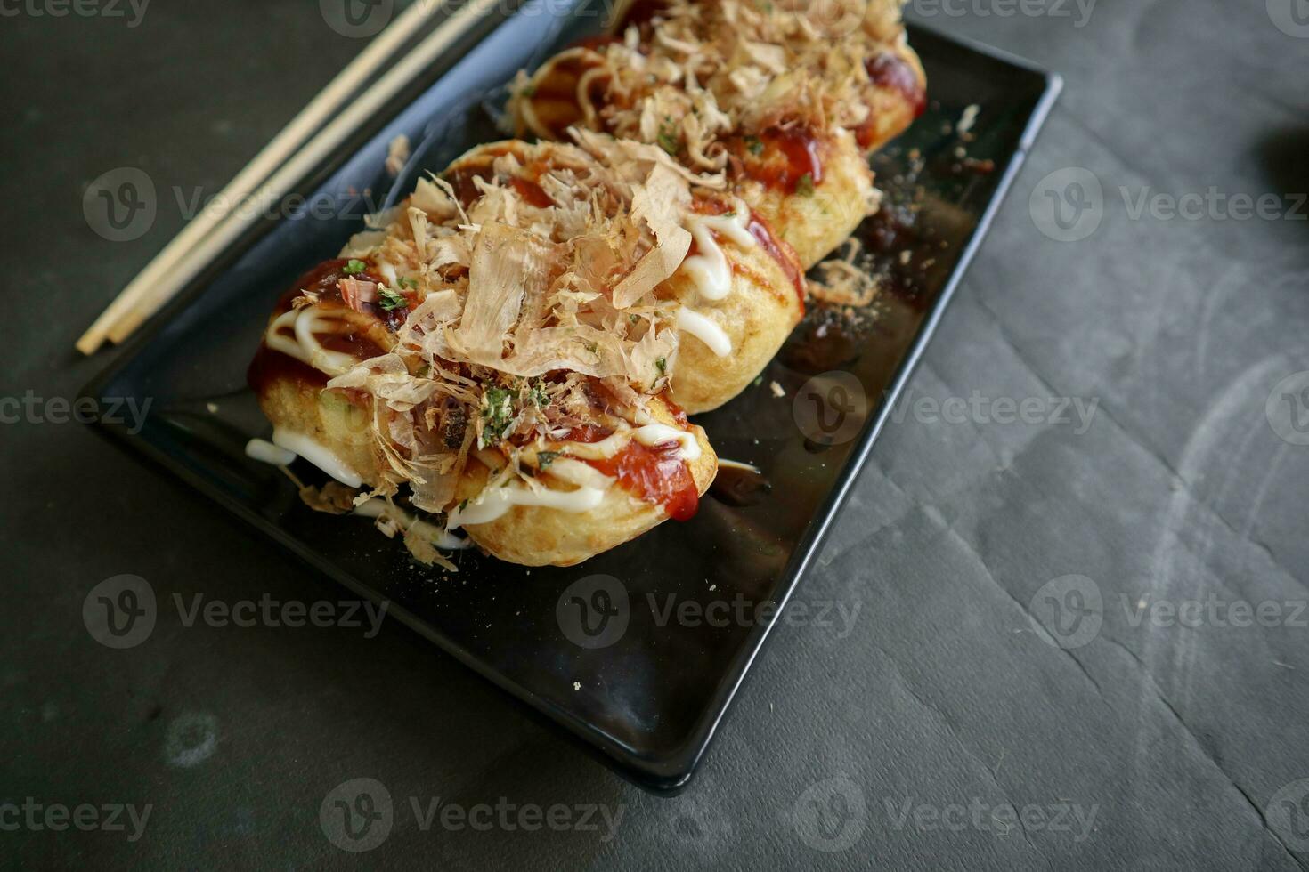 takoyaki è un' giapponese cibo, fatto a partire dal Grano Farina Impasto, polpo carne, o altro ripieni, servito con salsa, Maionese e guarnizione nel il modulo di katsuobushi o legna pesce trucioli. foto