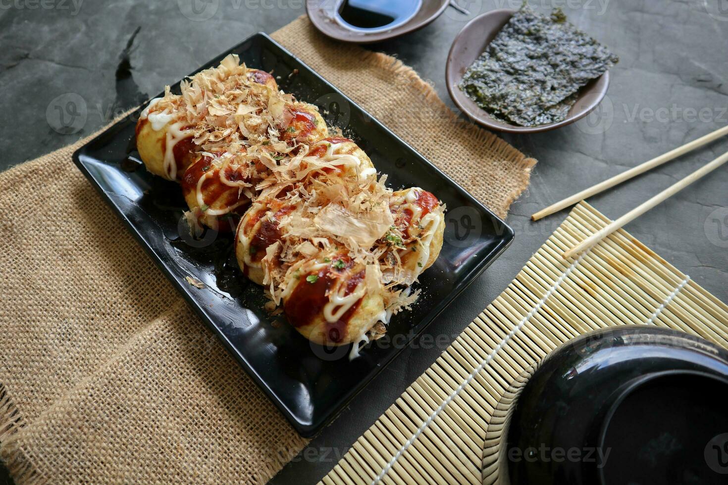 takoyaki è un' giapponese cibo, fatto a partire dal Grano Farina Impasto, polpo carne, o altro ripieni, servito con salsa, Maionese e guarnizione nel il modulo di katsuobushi o legna pesce trucioli. foto