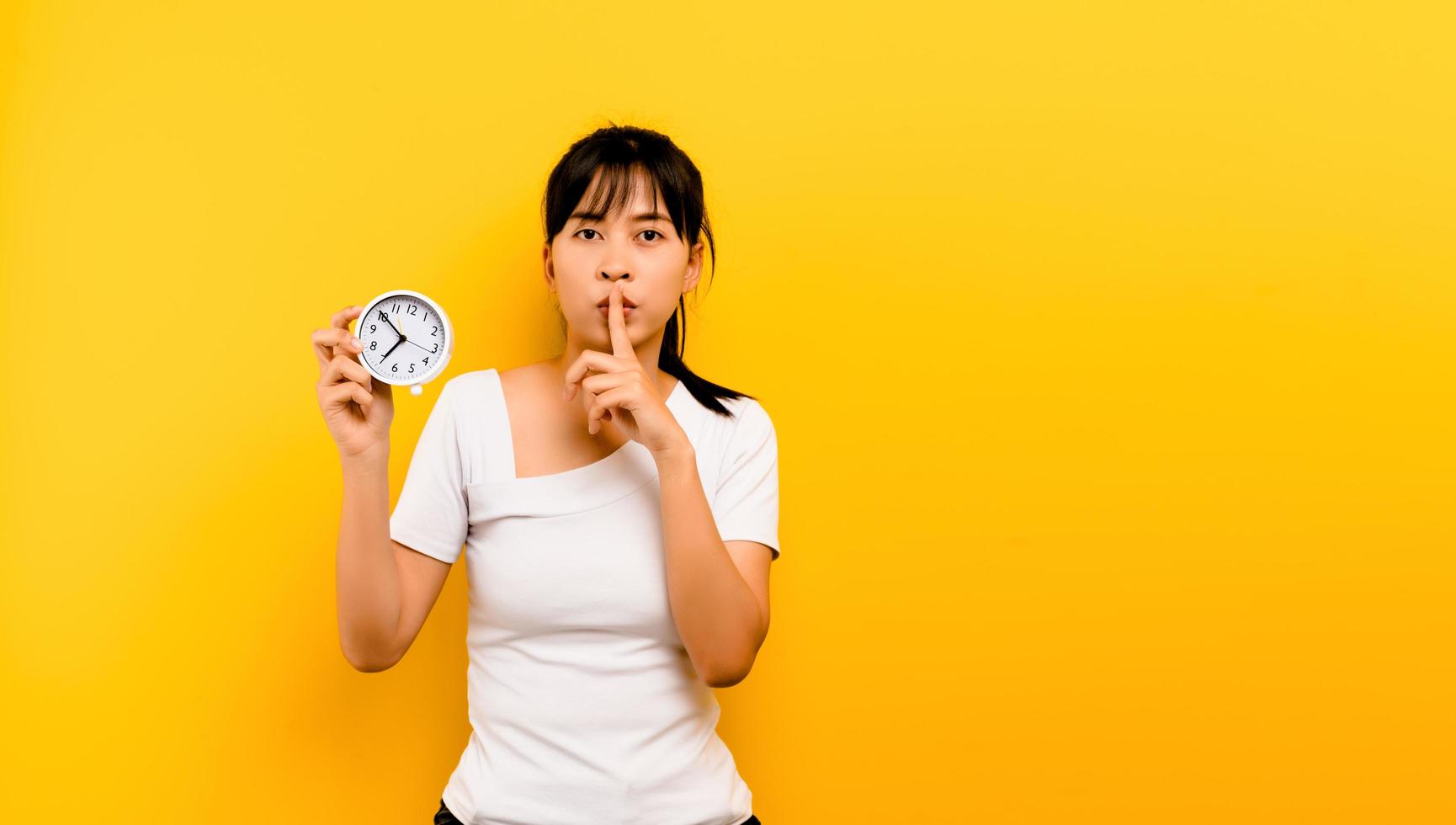 mattina piantare orologio donna asiatica che tiene una sveglia foto