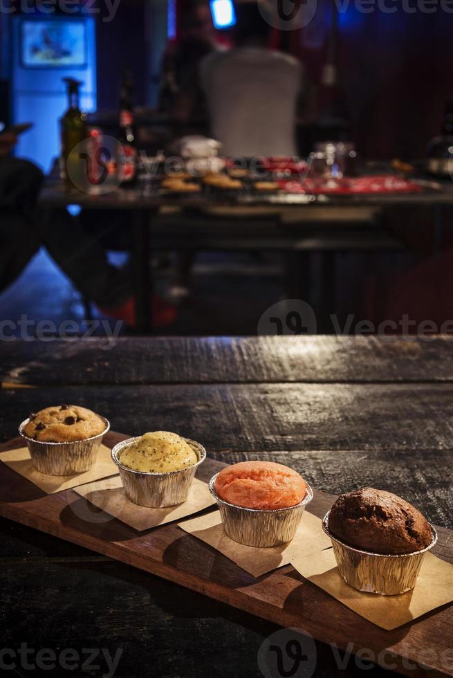 Muffin misti appena sfornati sul tavolo nell'accogliente interno della caffetteria foto