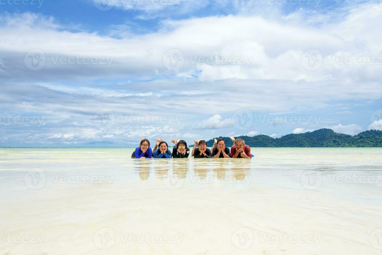 contento famiglia dire bugie insieme su il spiaggia, Tailandia foto