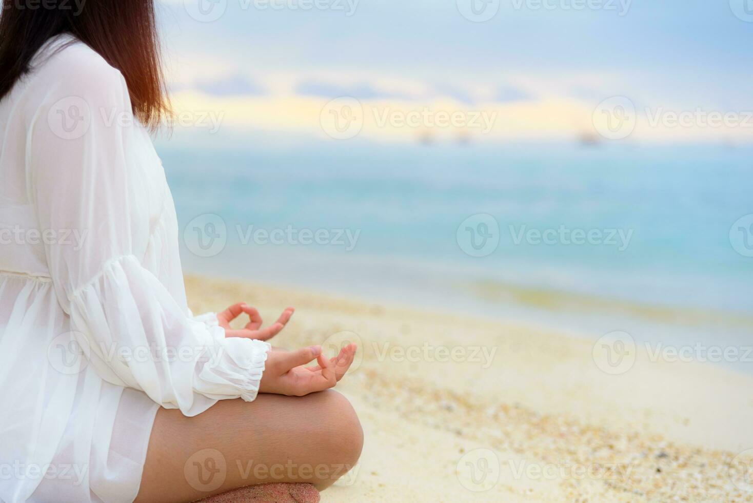 asiatico giovane donna praticante yoga su il spiaggia foto