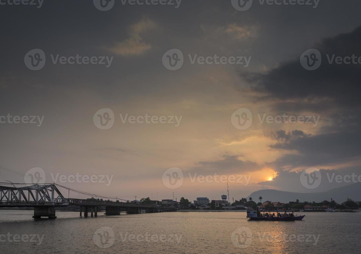 punto di riferimento vecchio ponte e fiume al tramonto in kampot cambogia foto