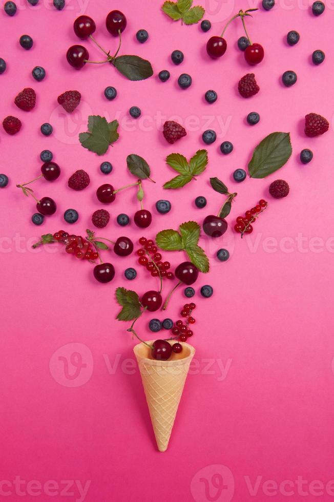 ciliegia fresca con cono di cialda sullo sfondo rosa. idea di design. foto