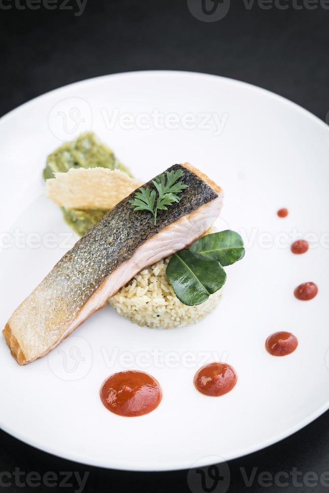 filetto di pesce salmone gourmet con guacamole di riso e salsa di peperoni rossi foto