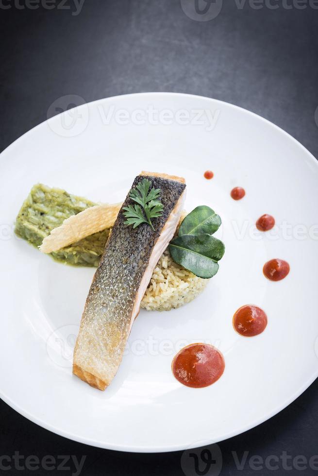 filetto di pesce salmone gourmet con guacamole di riso e salsa di peperoni rossi foto