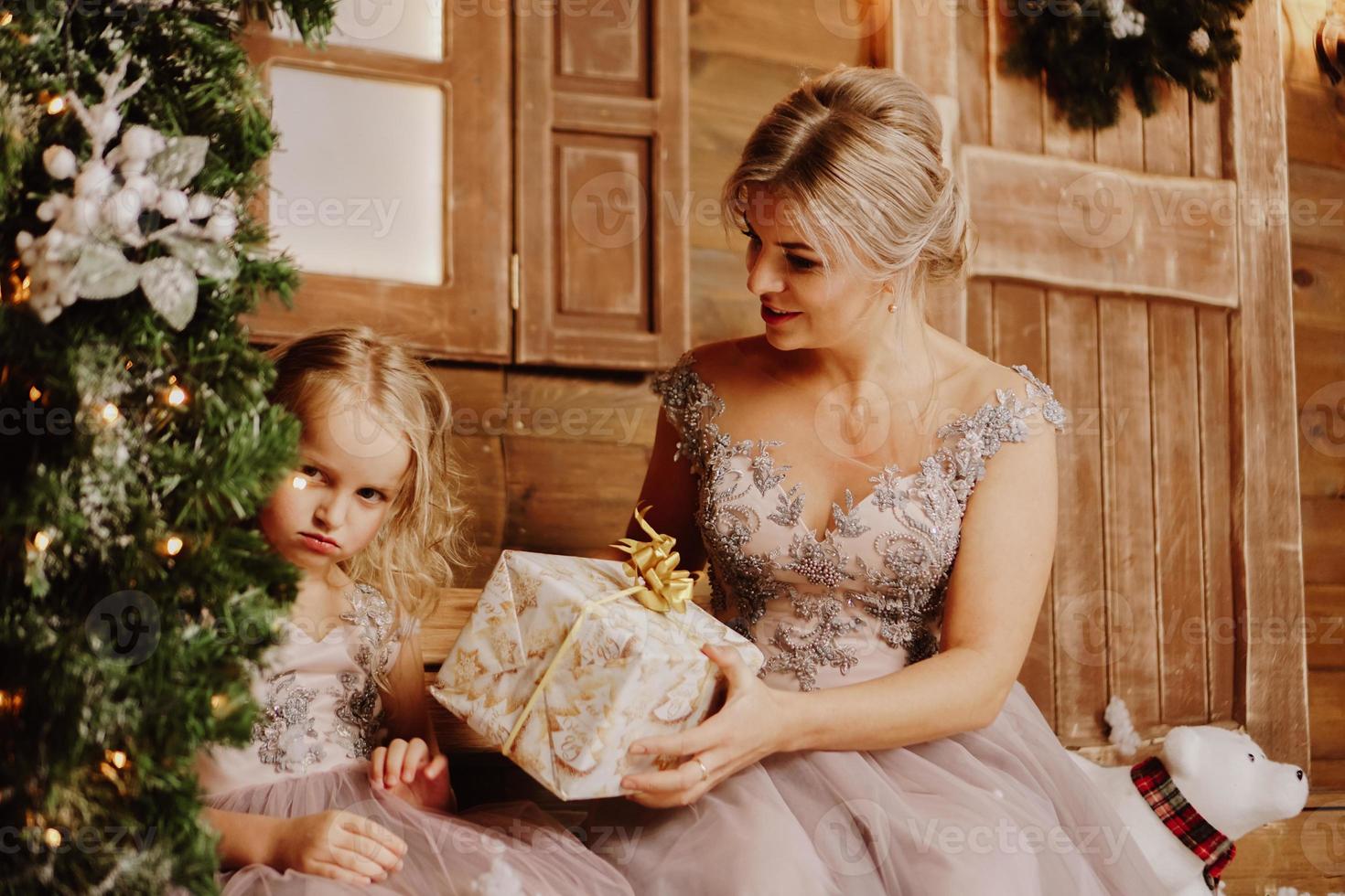 madre che calma la figlia che piange tristemente - albero di natale foto