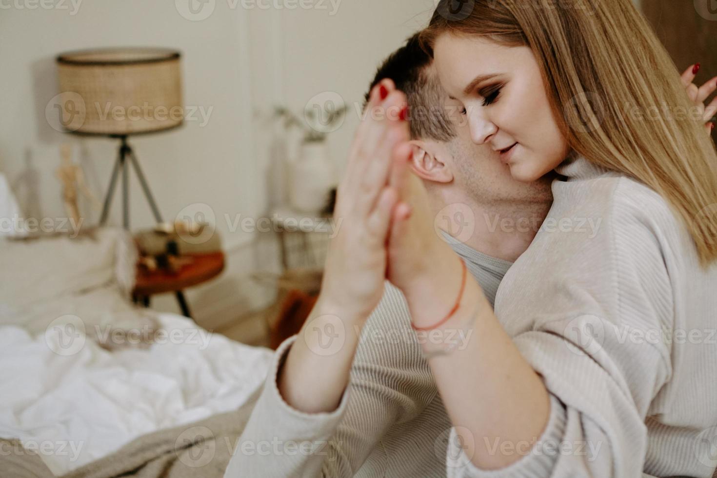 coppia che si tiene per mano a letto, gli amanti si abbracciano rilassandosi in camera da letto foto