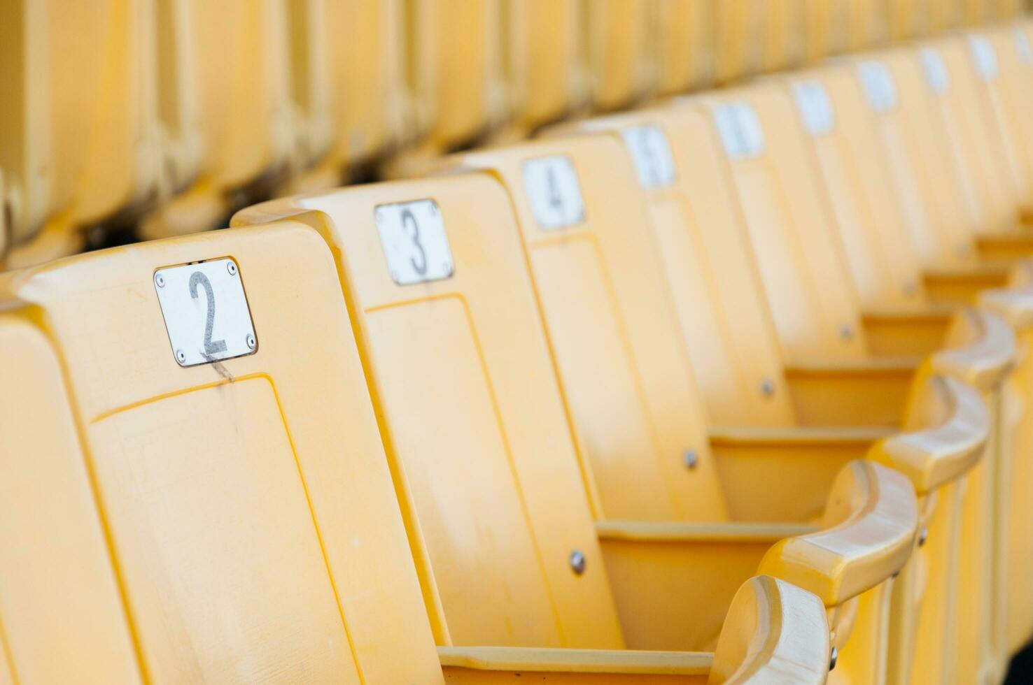 vuoto giallo posti a sedere a stadio, righe di posto a sedere su un' calcio stadio, selezionare messa a fuoco foto