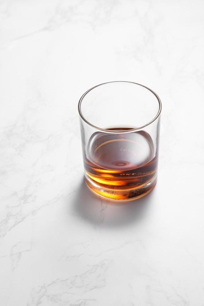 whisky scozzese in vetro su un tavolo di marmo bianco foto