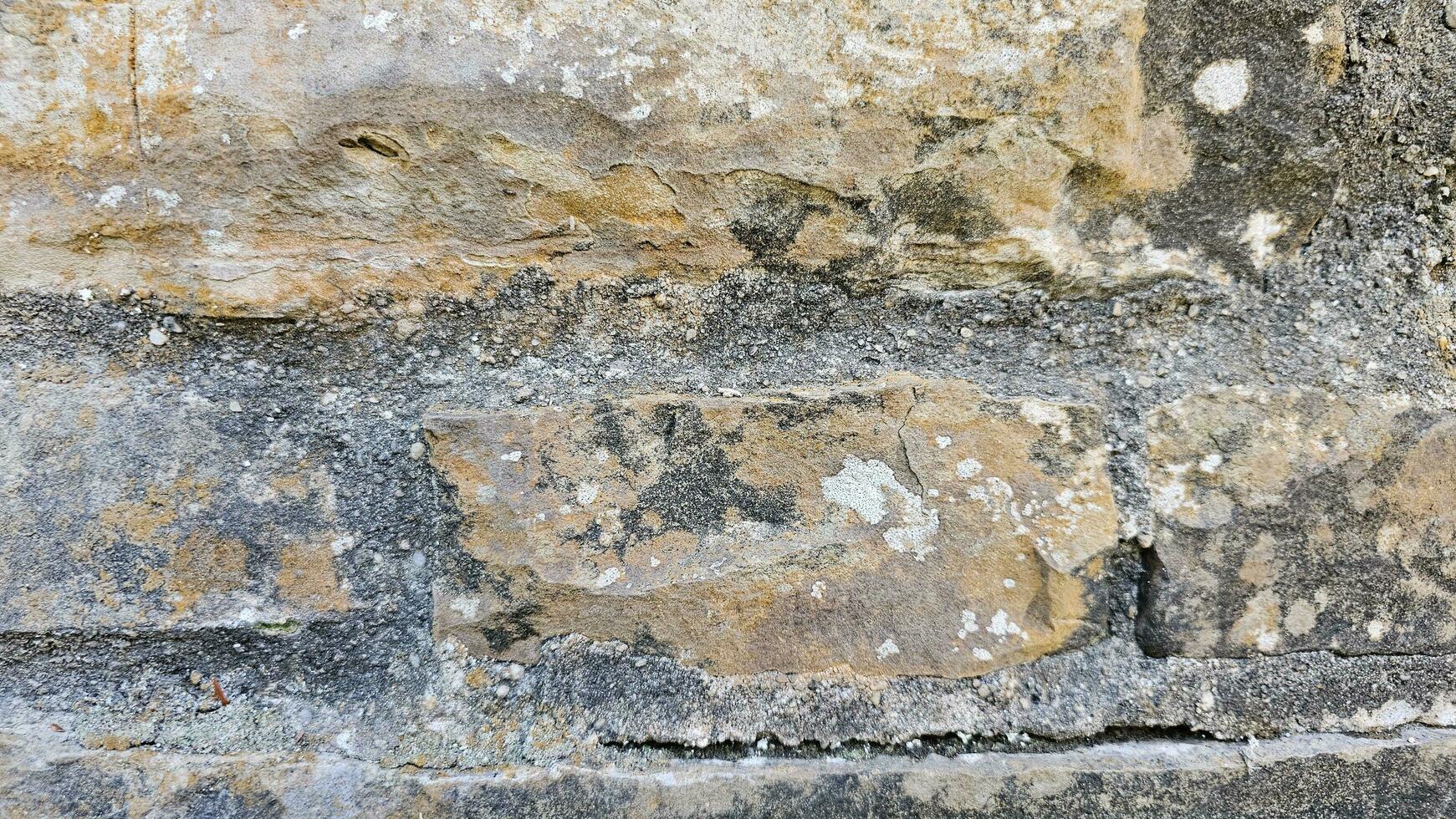 un' vicino su di un' pietra parete con alcuni peeling dipingere struttura foto
