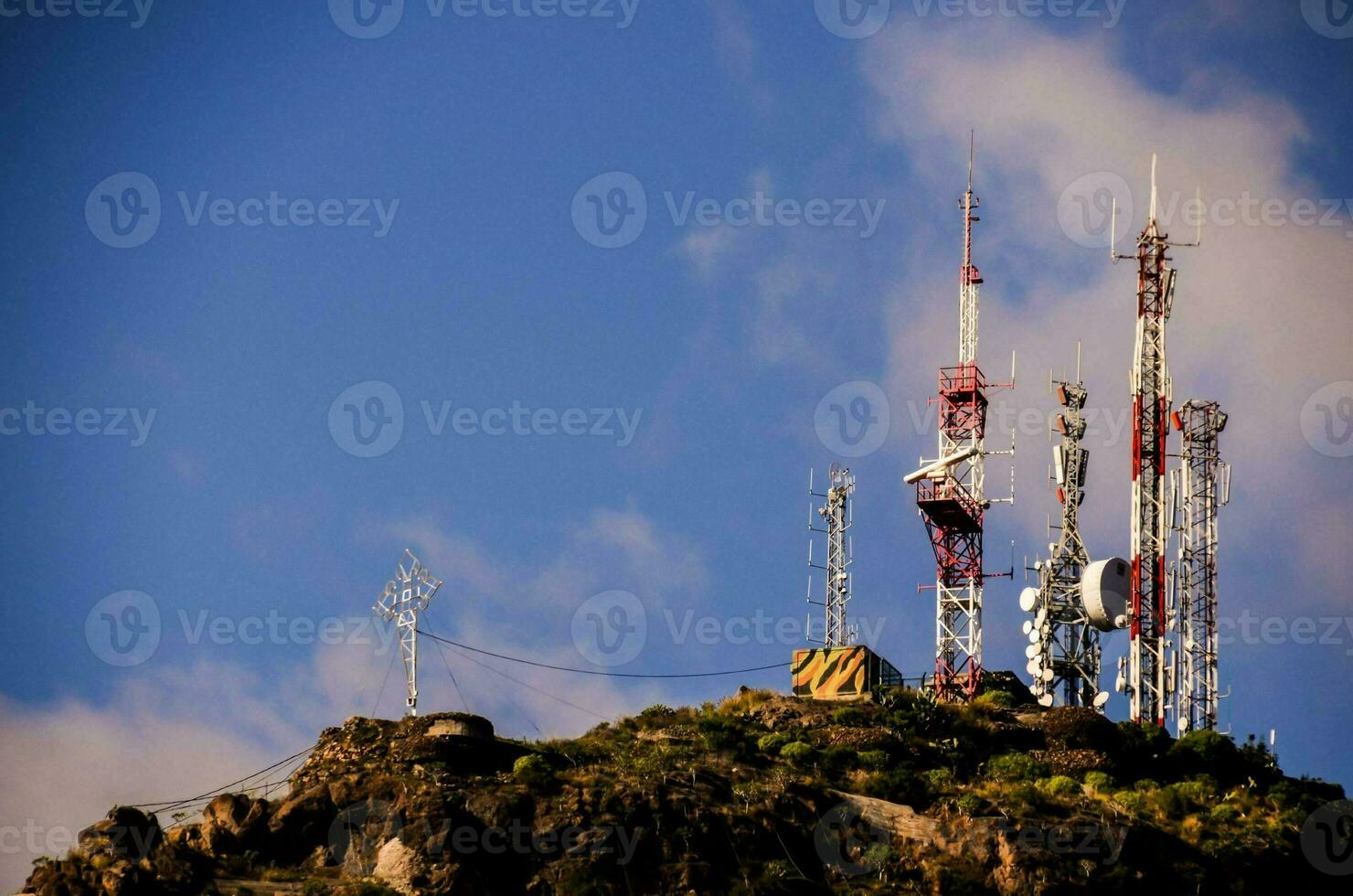 cellula torri su superiore di un' montagna con un' blu cielo foto