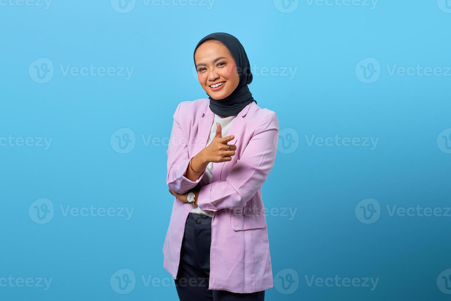 attraente donna asiatica che fa bene indicando su sfondo blu foto