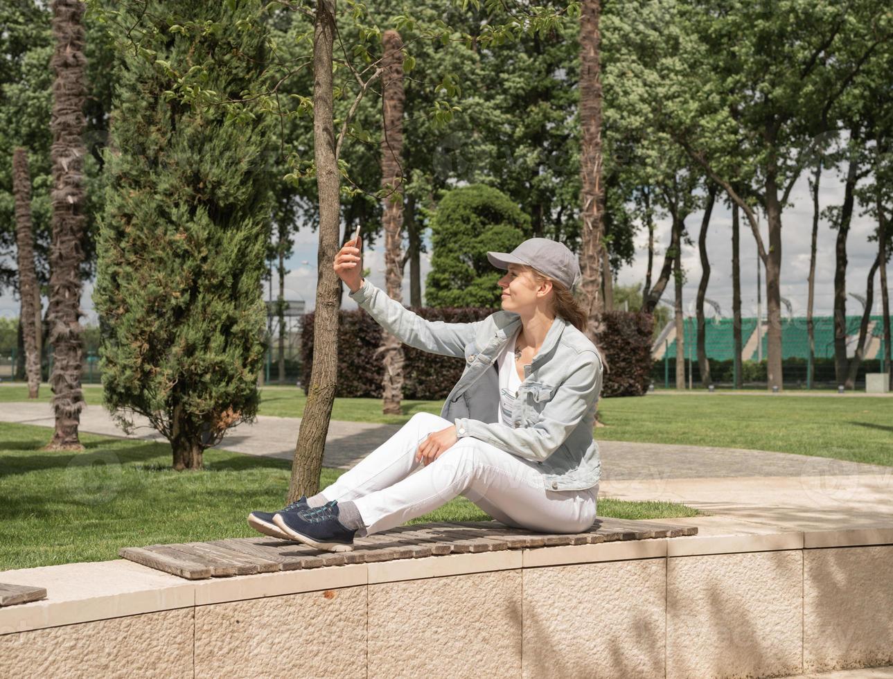 donna all'aperto che si fa selfie con il cellulare foto