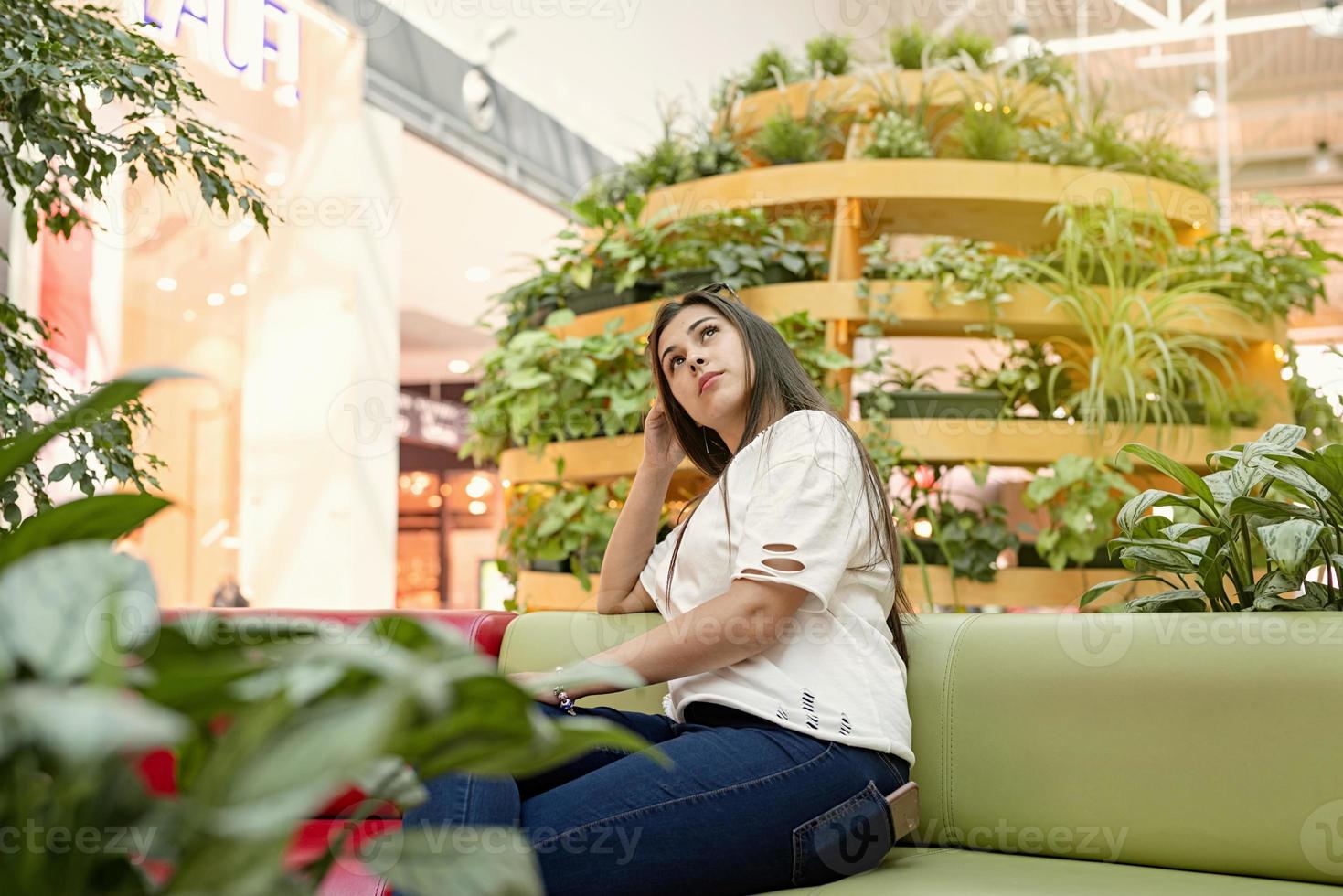 giovane donna seduta sul divano nel centro commerciale foto