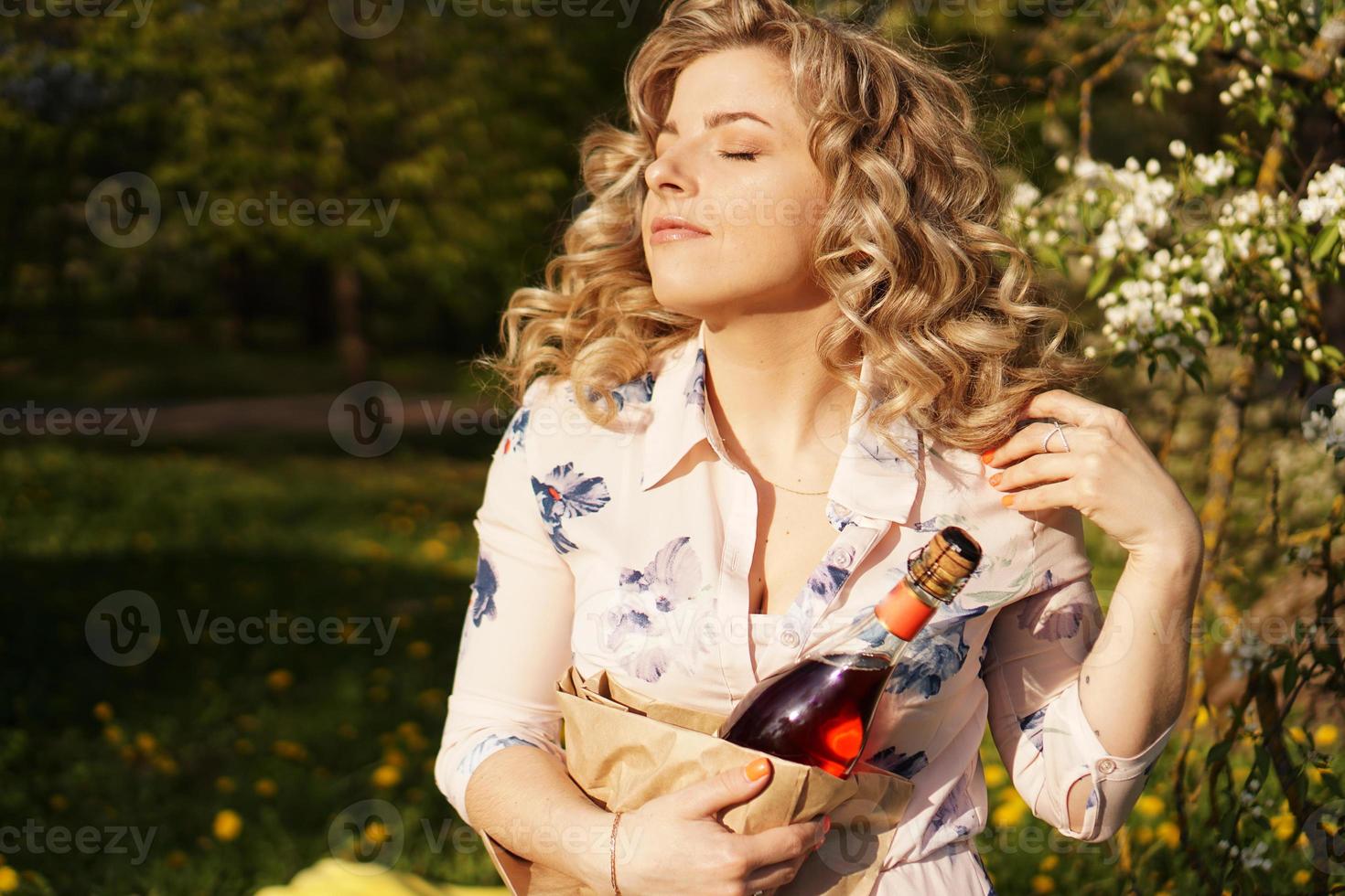 bella giovane donna con in mano una bottiglia di vino vuota foto