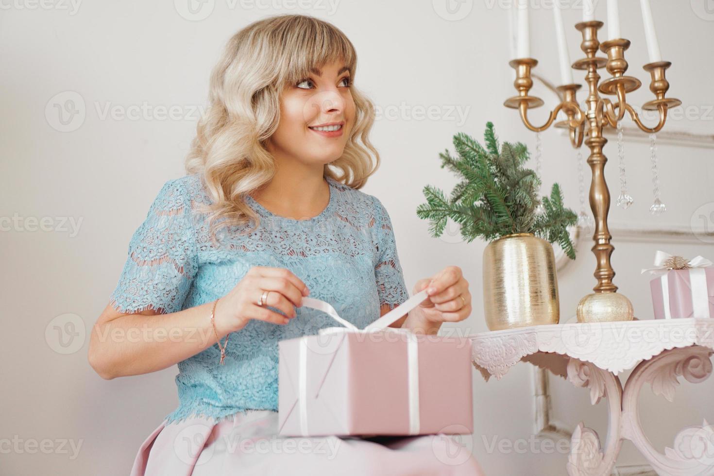 carina donna positiva vicino all'albero di Natale, regalo di apertura foto