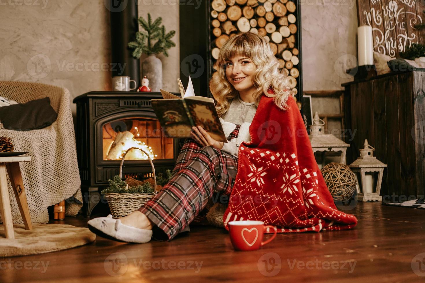 libro di lettura felice della giovane donna davanti all'interiore di natale foto