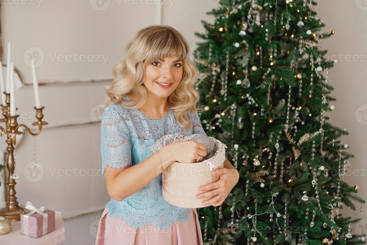 la giovane donna decora l'albero di natale con i giocattoli di natale foto