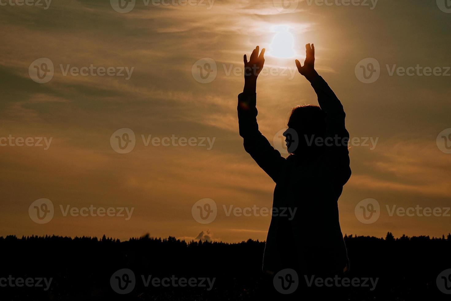 donna che gode del tramonto. silhouette femminile nel campo al tramonto foto