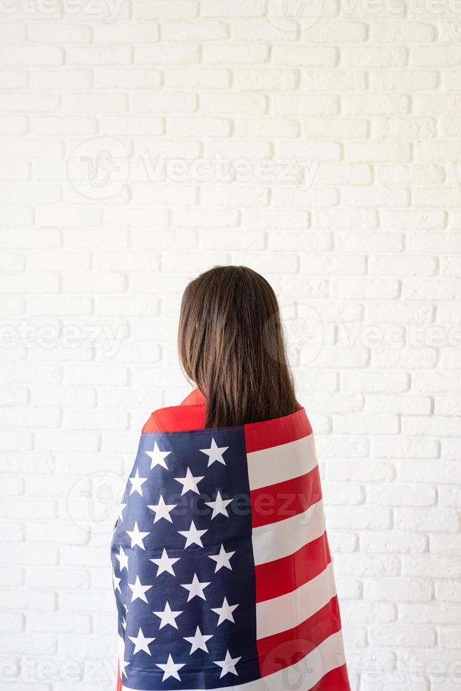 bella giovane donna con bandiera americana, vista posteriore foto