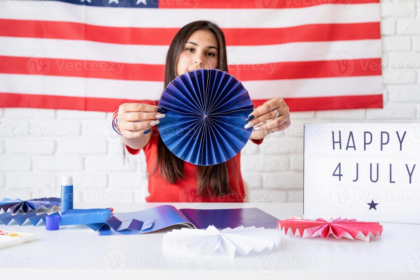 donna che fa ventagli di carta dei colori rosso e blu, celebrando foto