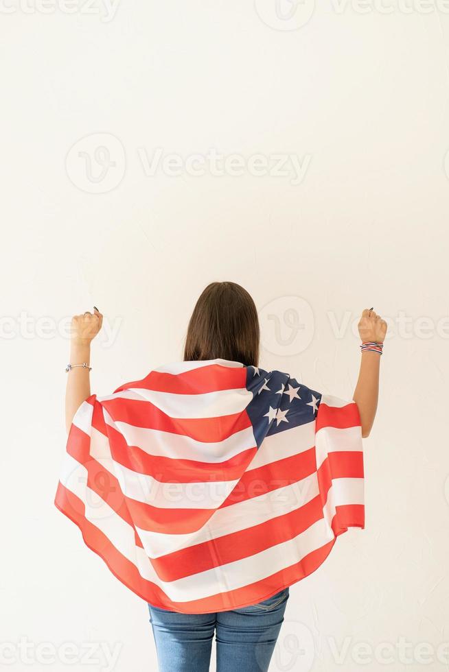 giovane donna con bandiera americana, vista da dietro foto