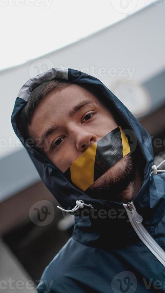 uomo con del nastro adesivo sulla bocca foto