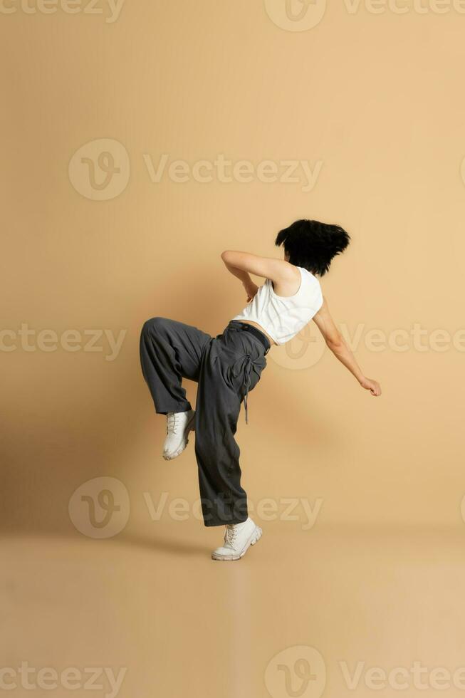 Immagine di asiatico ballerino danza su beige sfondo foto