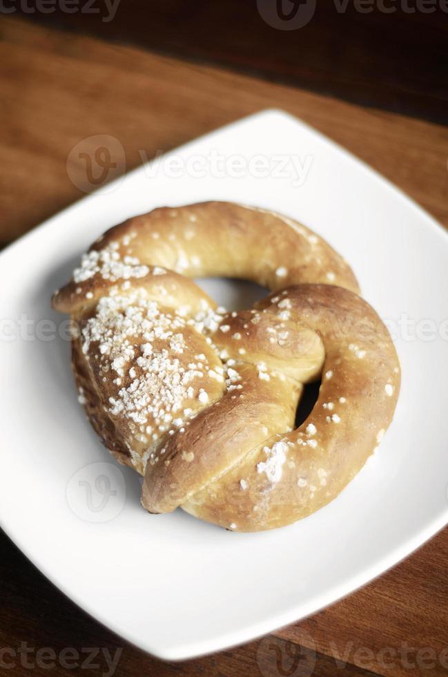 Pane pretzel tradizionale tedesco biologico senza latticini vegano su tavola di legno foto