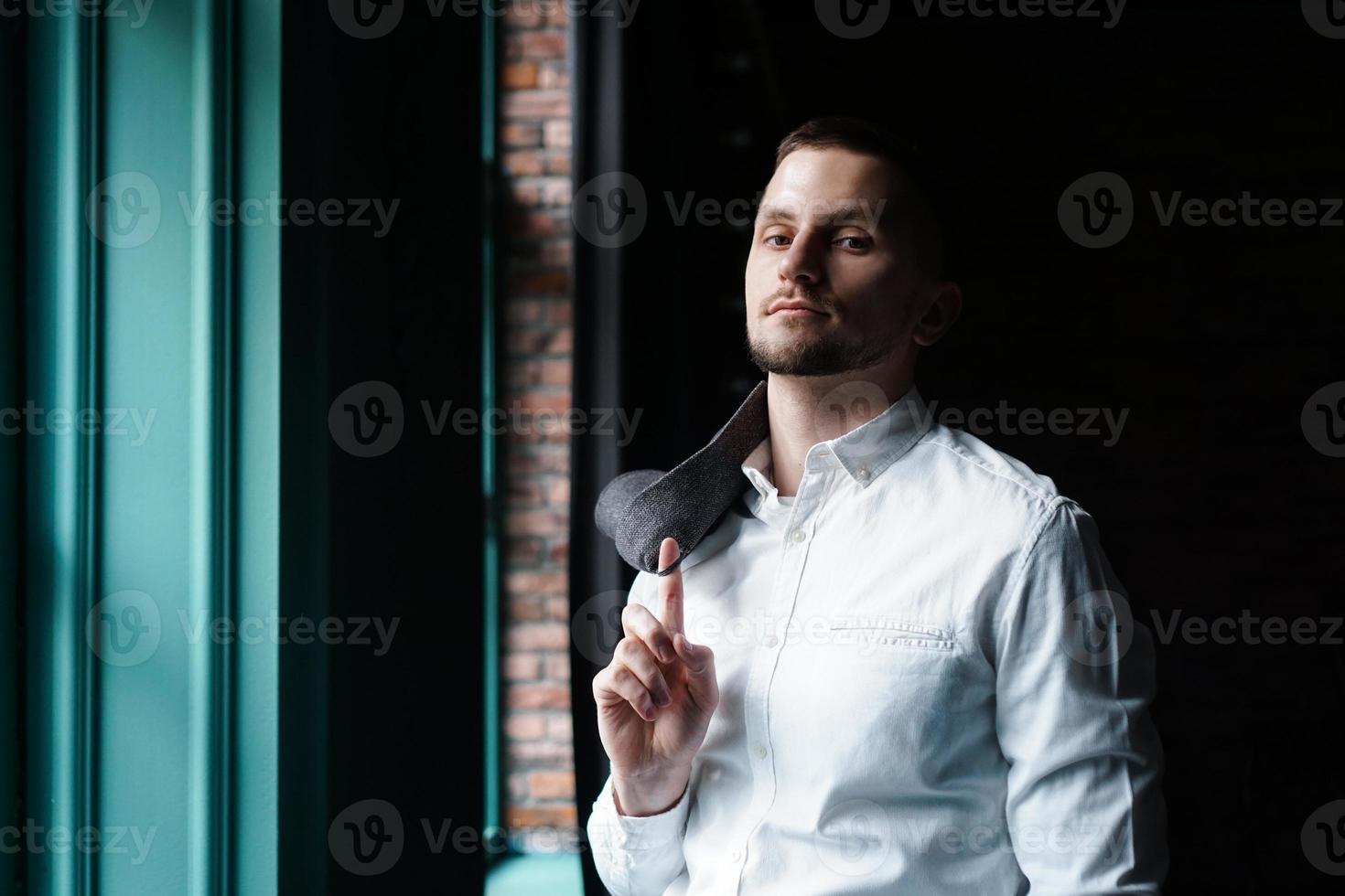 vista di profilo di un giovane uomo d'affari in piedi vicino alla finestra foto