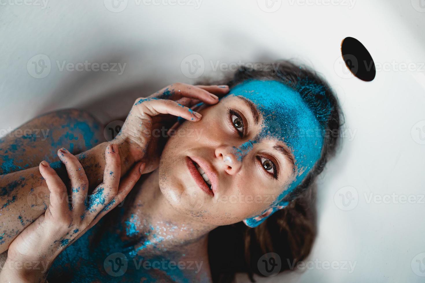donna con scintillii sul viso. ragazza nella vasca da bagno foto