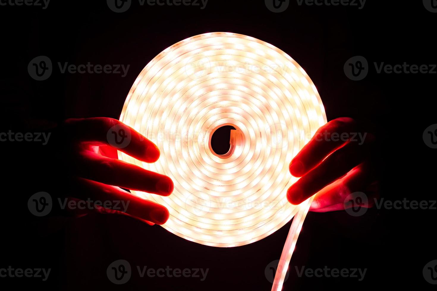 striscia luminosa a led, illuminazione a diodo a bobina rossa in mano foto