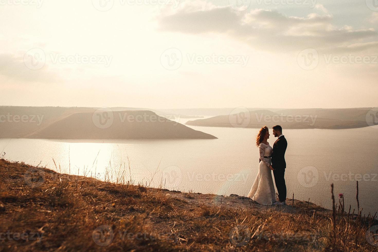 coppia sposata che si abbraccia su una montagna foto