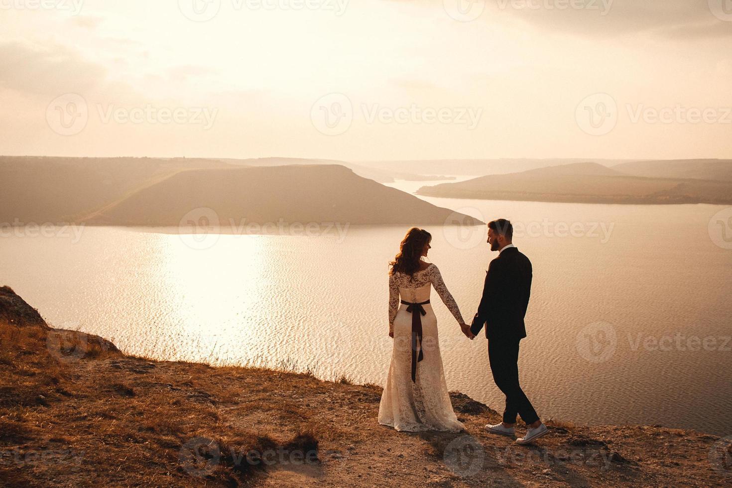 coppia sposata che si abbraccia su una montagna foto
