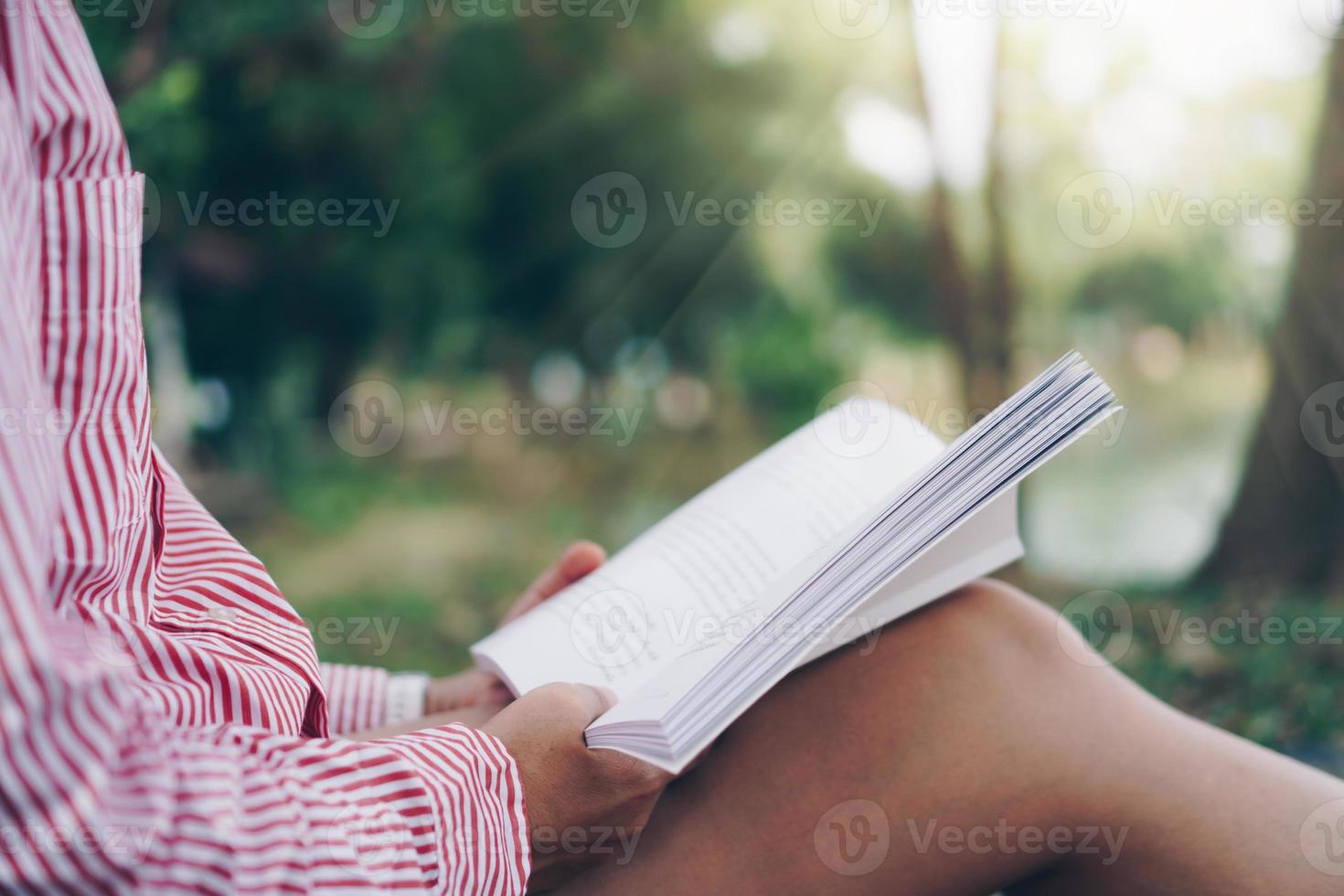 la donna sta leggendo il libro nel bellissimo parco e lo stagno si rilassano. foto