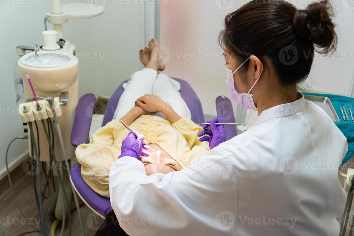 dentista che controlla i denti foto