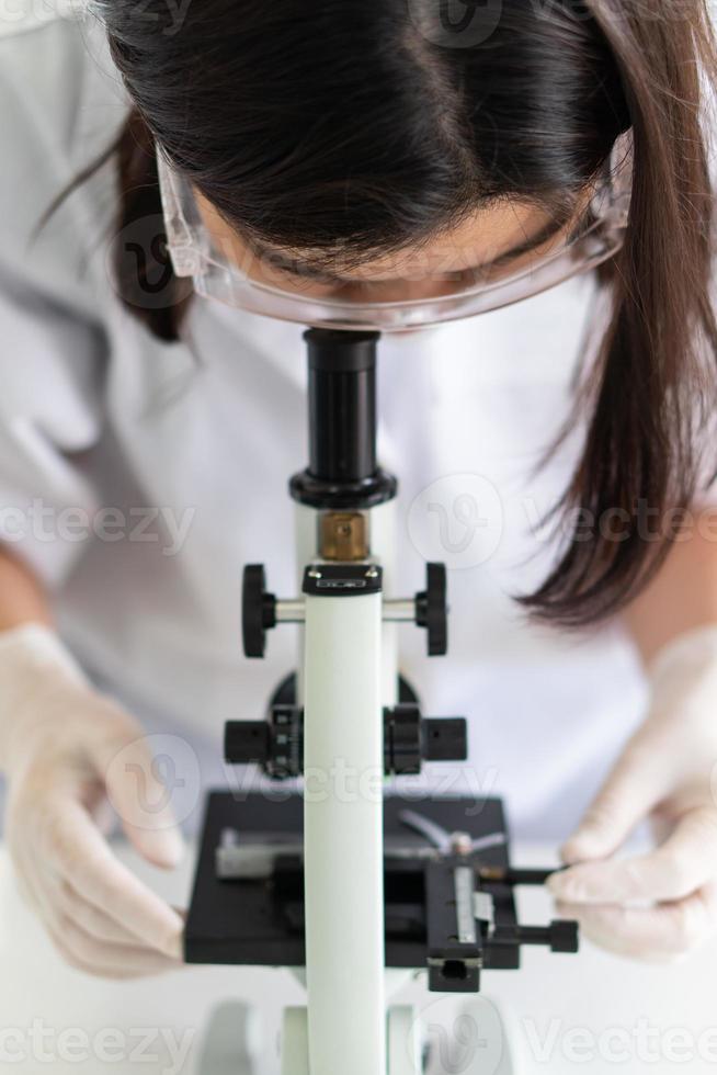 scienziato che usa il microscopio foto