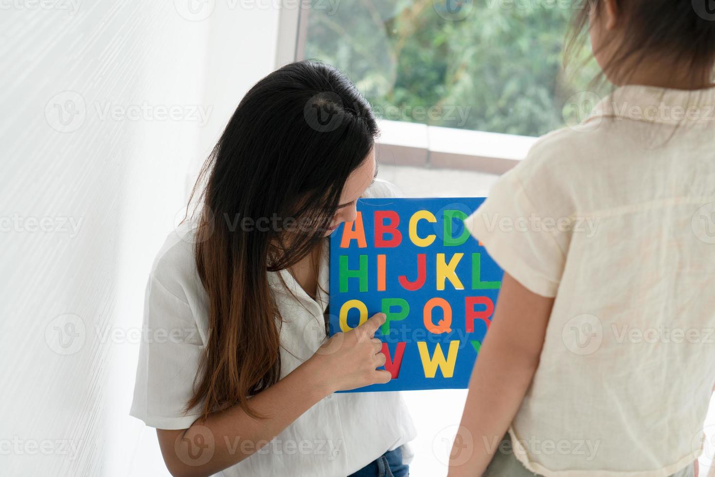 madre che insegna al bambino l'alfabeto foto