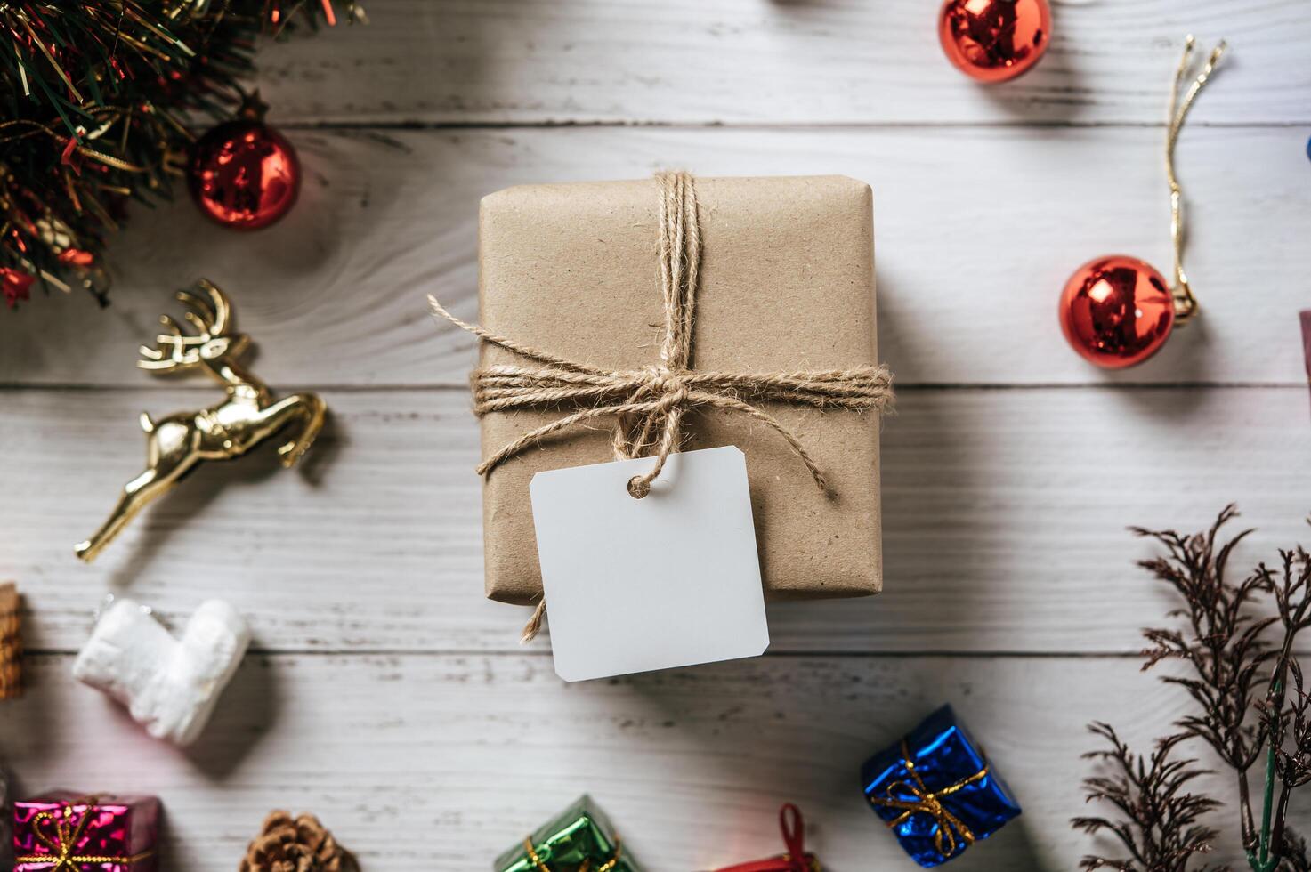 confezione regalo con un piccolo regalo su uno sfondo di legno bianco foto