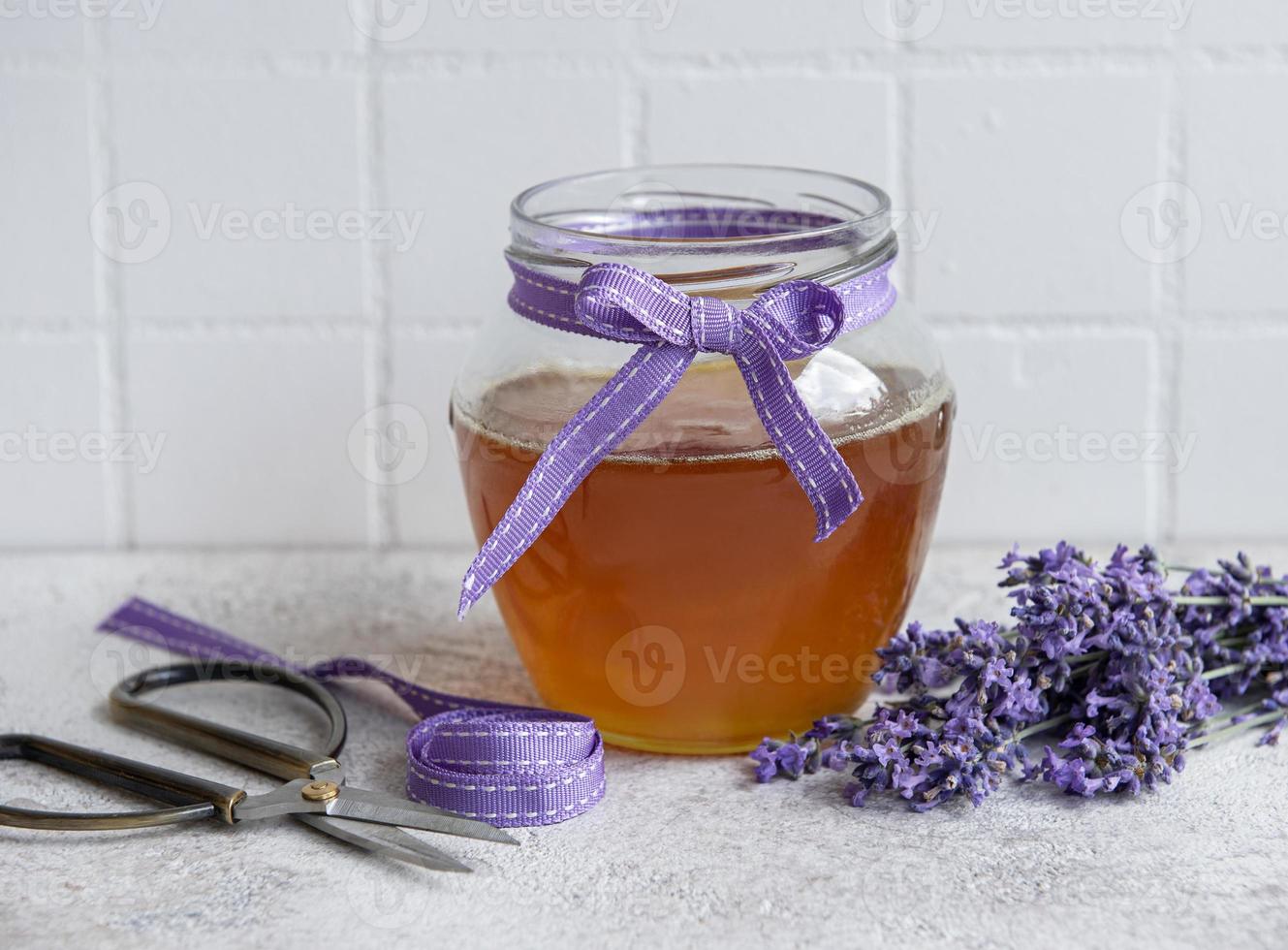 vasetto con miele e fiori di lavanda fresca foto