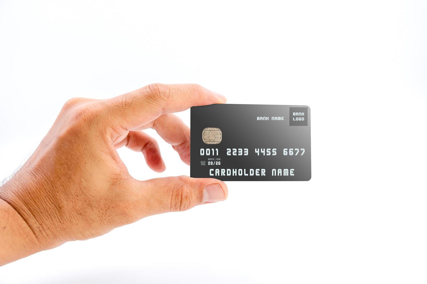 mano umana che tiene la carta di credito della banca di colore nero su sfondo bianco. foto