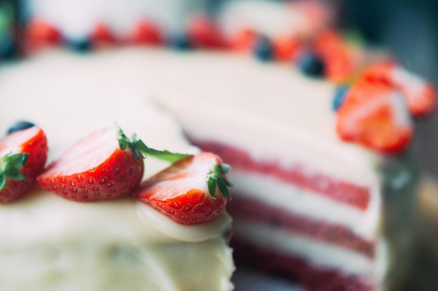 Torta con messa a fuoco macro selettiva con frutti di bosco e glassa bianca foto