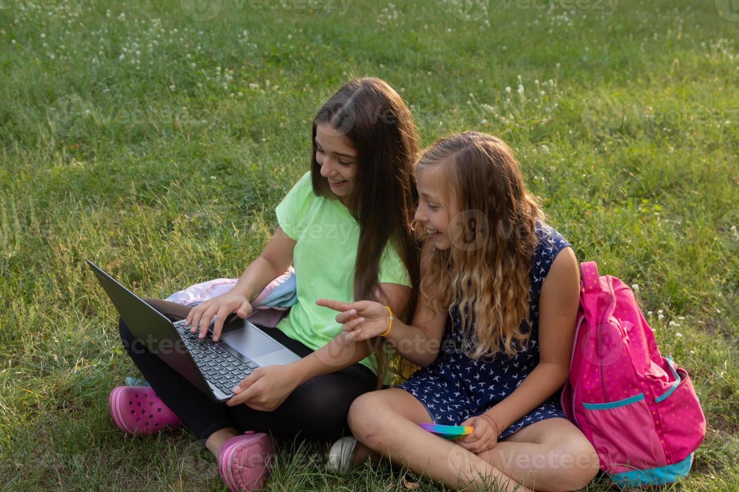 ragazze con laptop e valigette che fanno i compiti o si divertono foto