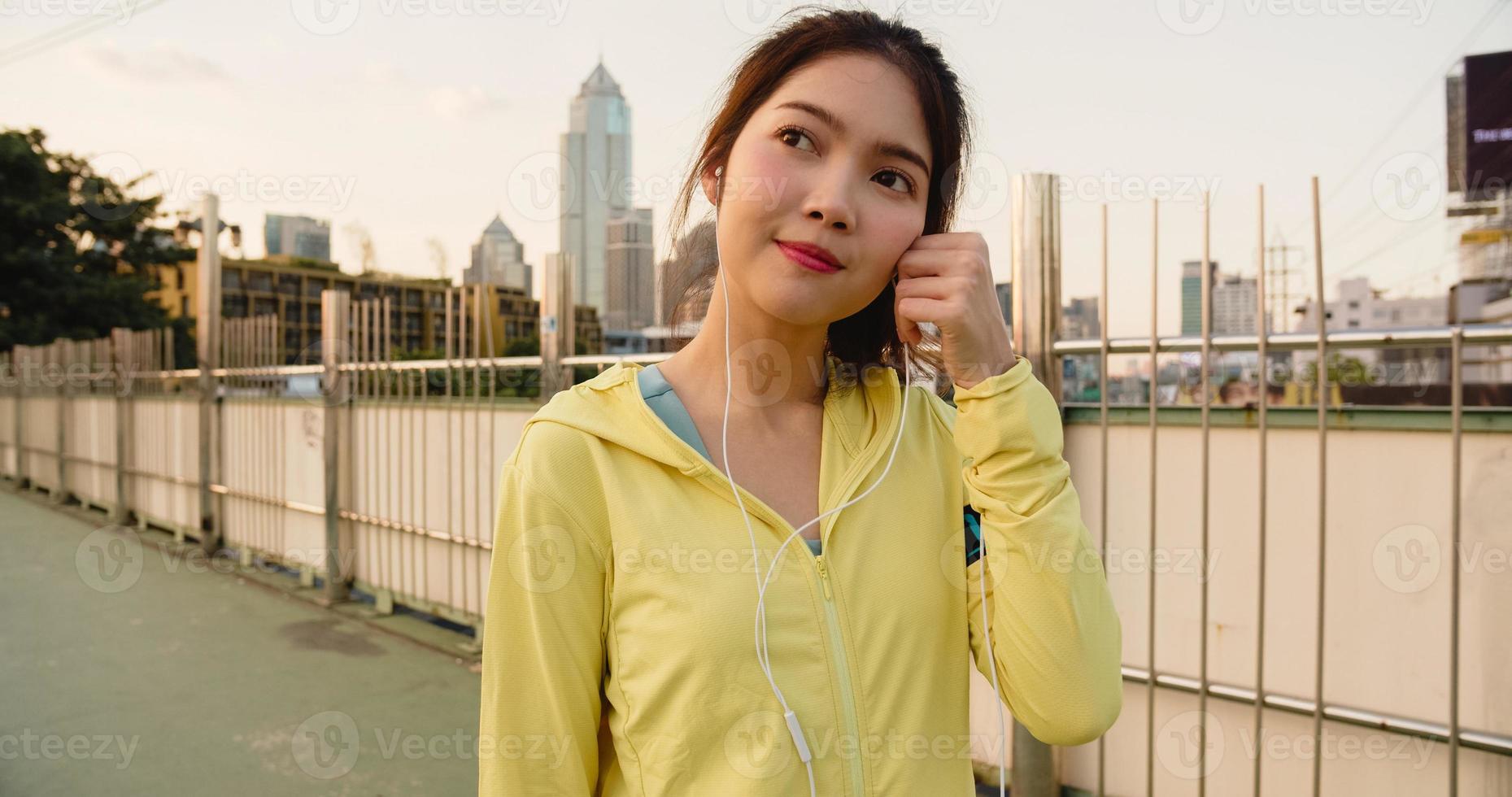 la signora dell'atleta dell'asia si esercita utilizzando lo smartphone per ascoltare la musica. foto