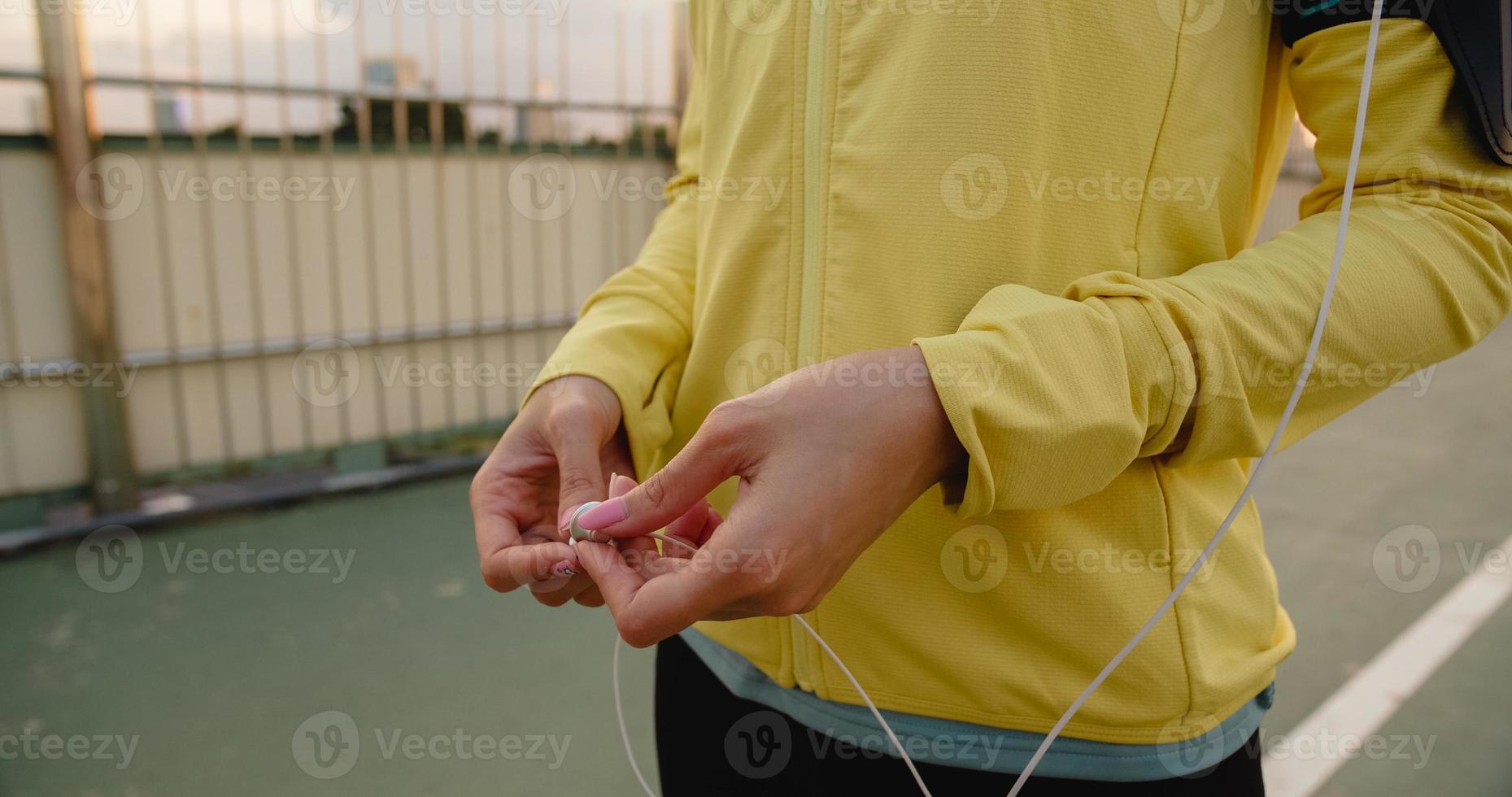 la signora dell'atleta dell'asia si esercita utilizzando lo smartphone per ascoltare la musica. foto