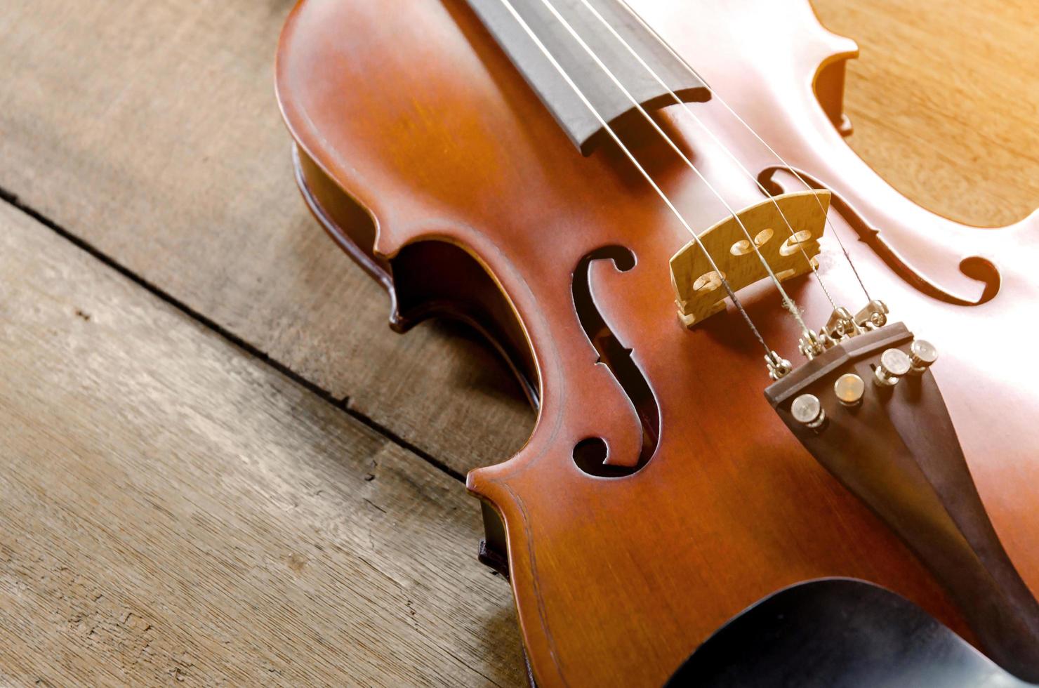 il violino sul tavolo, primo piano del violino sul pavimento di legno foto